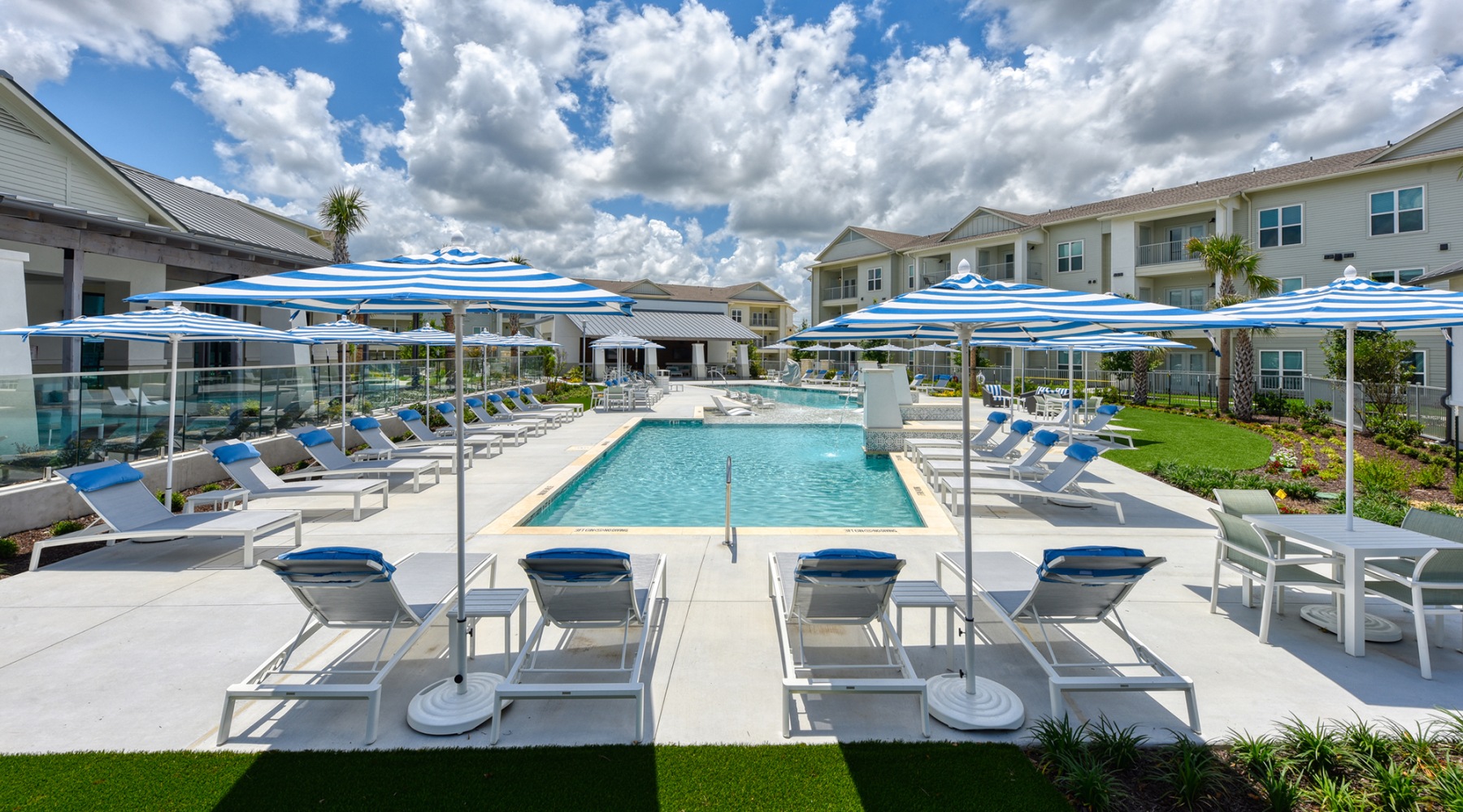 umbrella shaded loungers surround pool